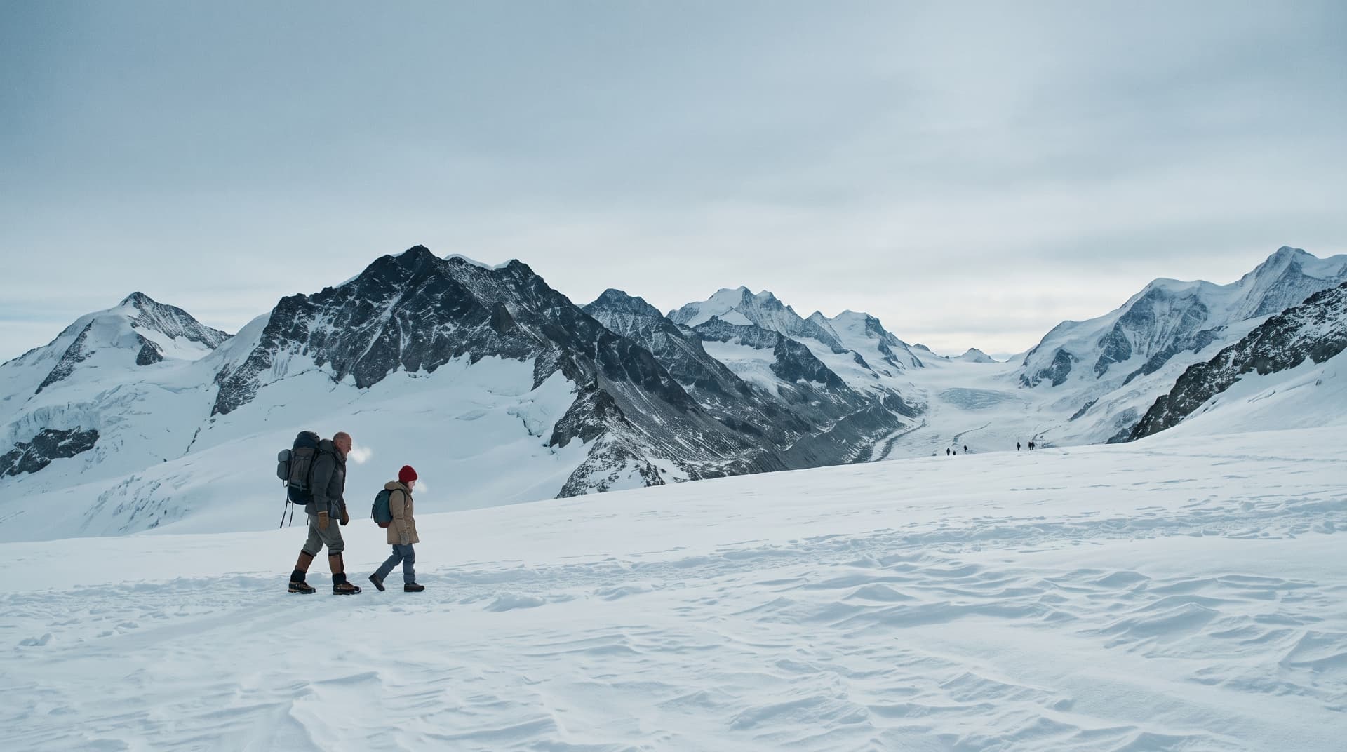 Two hikers crossing a snowfield