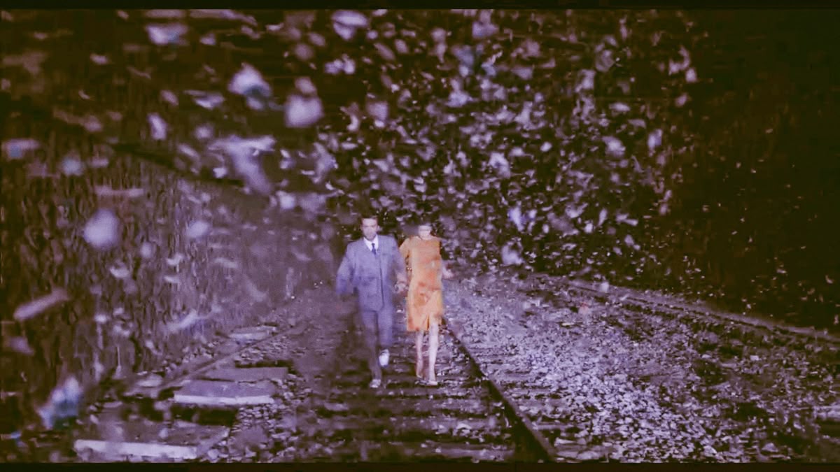 Couple on train tracks with debris